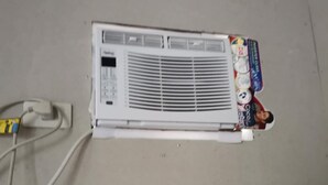 A white air conditioner unit with a control panel and a power cord plugged in. - 1 Bed House - Sleeps 2 - Parking - Wifi (Zamboanga)