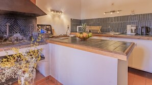 A modern kitchen with a wooden countertop, a built-in stove, and a coffee maker. - La Chênaie by Interhome (Oraison)