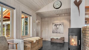 Un salon chaleureux avec une cheminée, des meubles en bois et une grande horloge au mur.