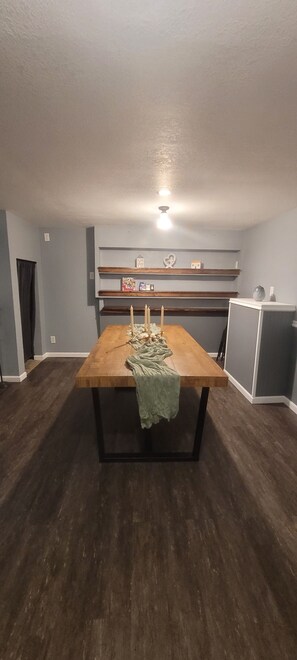 Enjoy meals at the dining table, surrounded by decorative objects and a small cabinet.
