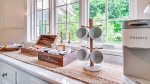 Eine Küche mit einer Kaffeestation, einer Keurig-Kaffeemaschine und Blick auf Grünfläche.