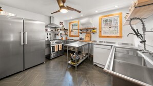 Una cocina moderna con electrodomésticos de acero inoxidable, una isla central y detalles de madera.