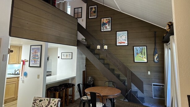 A multi-level home interior with a staircase, dining area, and various framed artworks on the walls. - New Remodeled Studio-Loft Convenient to Town & Bus (Mammoth Lakes)