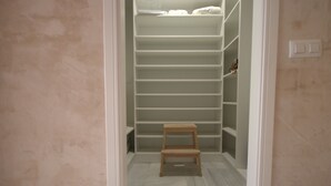 A walk-in closet with multiple shelves and a wooden step stool. - 170 Tarek Puerto (Tarifa)
