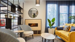 Una sala de estar moderna con chimenea, un sofá, una mesa de centro y una estantería.