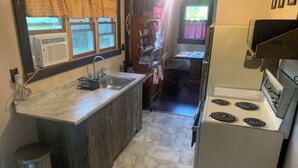 A compact kitchen with a central island, a stove, and a sink.