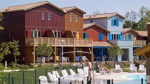 A hotel with colorful buildings, a swimming pool, and outdoor seating.