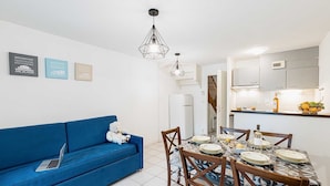 A modern kitchen with white cabinets, a built-in oven, and a fruit bowl on the counter.