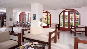 A spacious lobby with a coffee table, seating area, and bicycles.