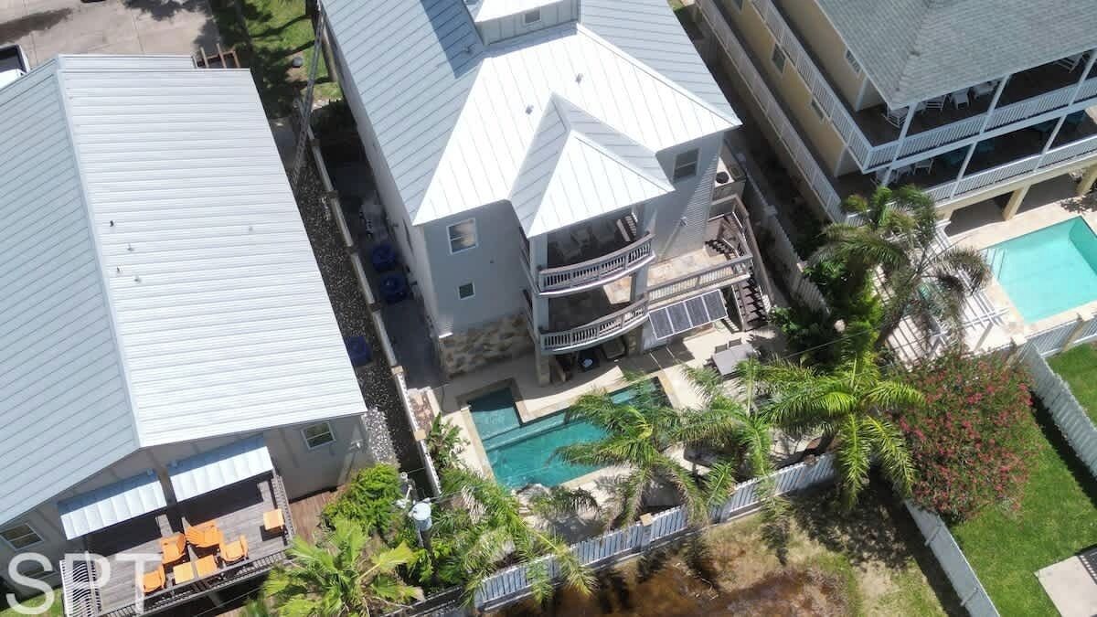 En bygning med flere etager, swimmingpool, balkoner og udendørs siddepladser.