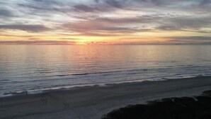 Ein Strand mit Sonnenuntergang über dem Ozean.