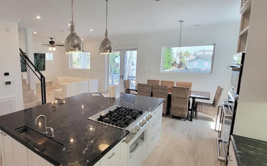 A modern kitchen with a central island, stainless steel appliances, and pendant lighting.