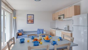 Een moderne keuken met een eethoek, met een ontbijtarrangement met kommen, fruit en drankjes.
