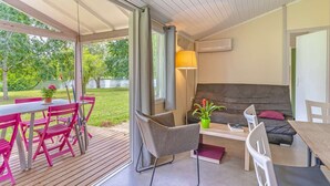 Un salon moderne avec un canapé, une table à manger et des chaises, et une vue sur un lac.