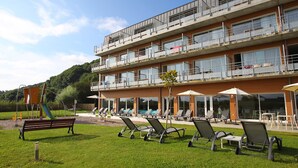A multi-story hotel with outdoor seating and a playground. - Appartement moderne au calme ! (Roz-Sur-Couesnon)
