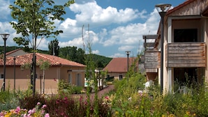 A residential area with houses, a garden with flowers, and a clear sky.