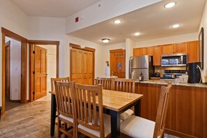 Una cocina moderna con armarios de madera, un refrigerador de acero inoxidable, un microondas y una cafetera.