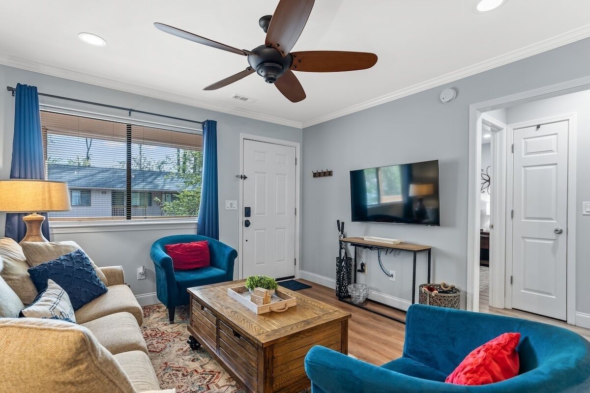 A living room with a ceiling fan, a television, and a coffee table.