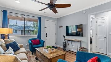 A living room with a ceiling fan, a television, and a coffee table.