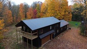 Una baita con veranda e garage, immersa nel foliage autunnale.