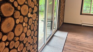 Una stanza con parete in legno, ampie porte scorrevoli in vetro e pavimento in legno.