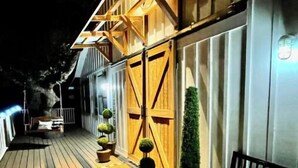A wooden deck with potted plants and a bench. - Texas Ambience at the Barn and Silo
 (Liberty Hill)
