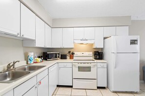 A modern kitchen with white cabinets, stainless steel appliances, and a dishwasher.
