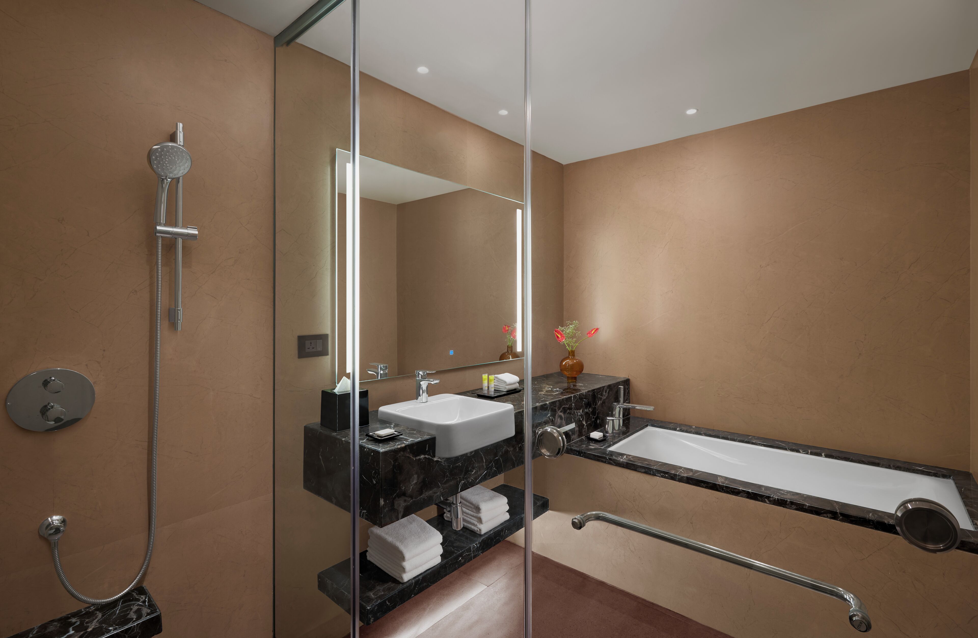 A modern bathroom with a glass-enclosed shower, a vanity with a sink, and a bathtub.