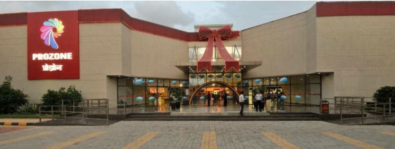 A building with a large red sign reading "PROZONE" and a prominent red bow above the entrance.