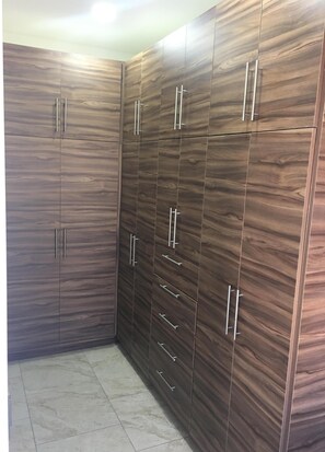 Features a multi-tiered wardrobe with solid panels and glass doors.