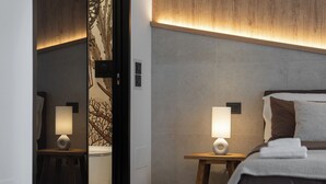 A modern bedroom with a bed, two bedside tables, and a mirror. - Leluan Bed & Breakfast (Mola di Bari)