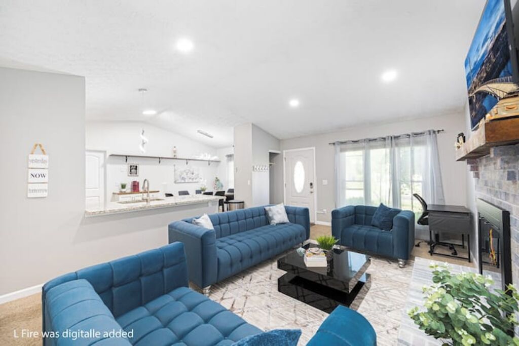 A modern living room with blue sofas, a black coffee table, and a fireplace.
