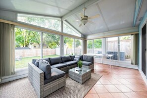 A covered patio with a sectional sofa, a coffee table, and a ceiling fan. - Charming Ranch 3BR W/ Hot Tub and Ping Pong Table

 (Dublin)