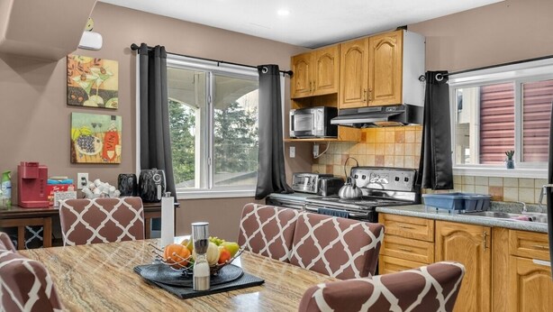 Una cucina moderna con mobili in legno, un tavolo da pranzo con sedie a fantasia e vista sull'esterno.