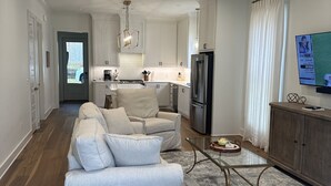Una sala de estar moderna con un conjunto de sofá, una mesa de centro y un televisor.