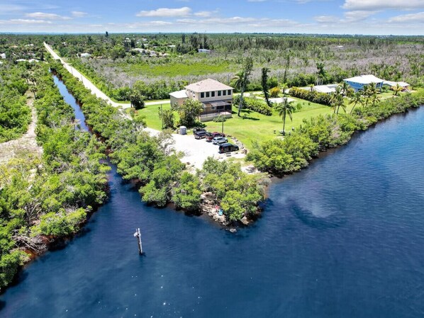 A coastal property with a large house, a dock, and a narrow water channel.
