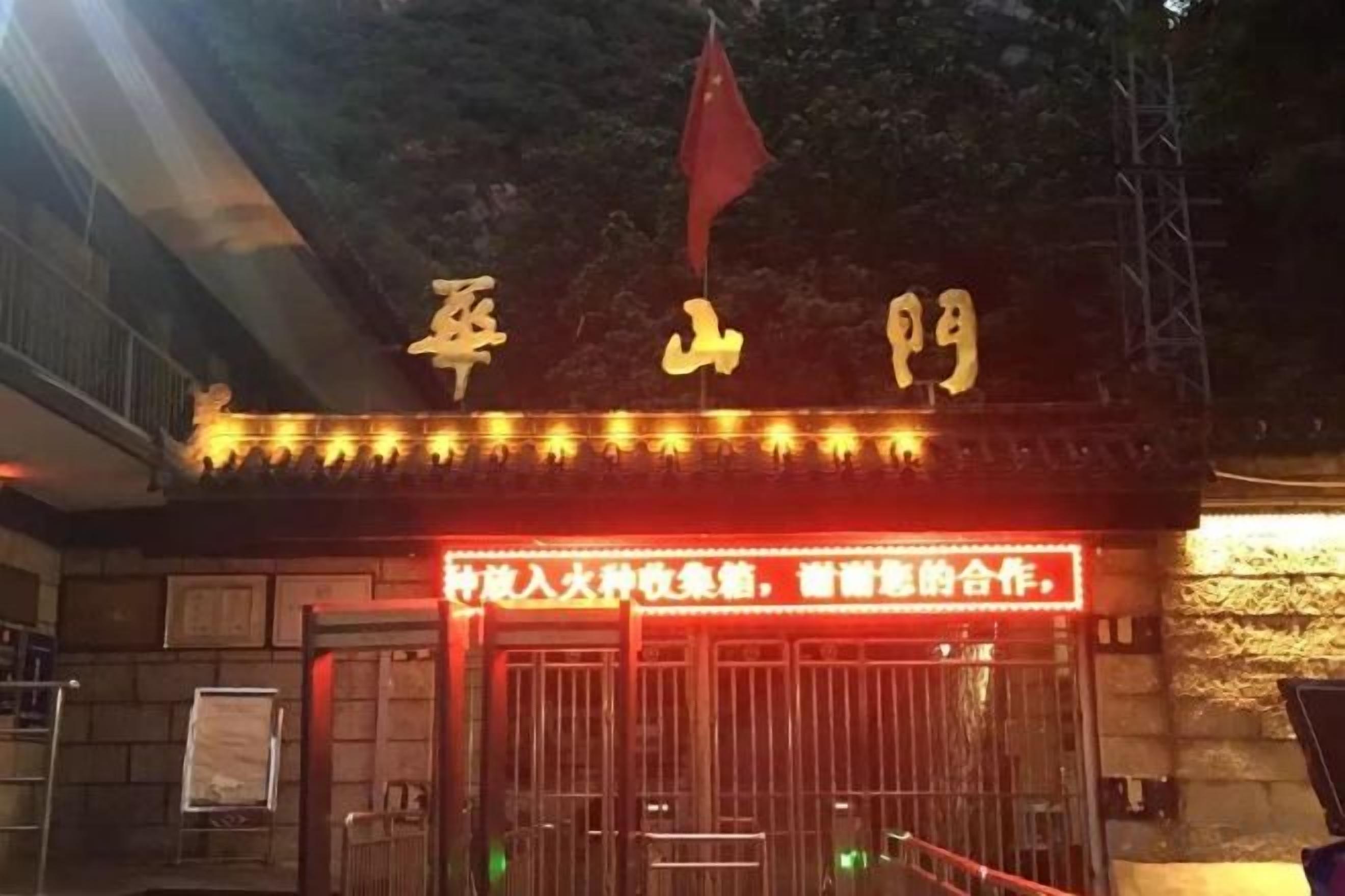 A building entrance with illuminated signage and a flag.