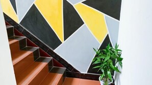 Eine Treppe mit geometrisch gemusterten Wänden und einer Topfpflanze.