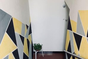 A hallway with geometric wall patterns and a potted plant. - Huashan Xinyi Inn (Huayin)