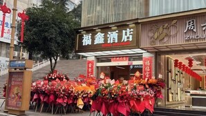 Un hotel de estilo arquitectónico chino tradicional, con una entrada destacada adornada con detalles rojos y un letrero.