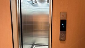 Un ascensor con pantalla digital que muestra el número de piso y un panel de botones.