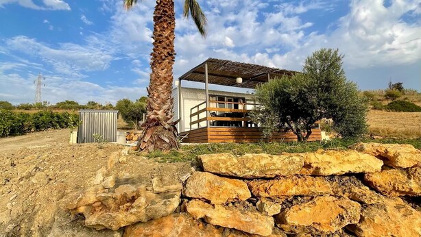 A modern building with a flat roof and a stone wall in the foreground. - Vacation homes Trinacria (Sicilia)