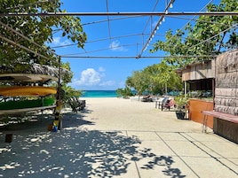 Playa privada, arena blanca, sillas reclinables de playa, sombrillas