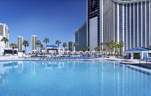 Relax by the pool surrounded by comfortable lounge chairs and shaded umbrellas.