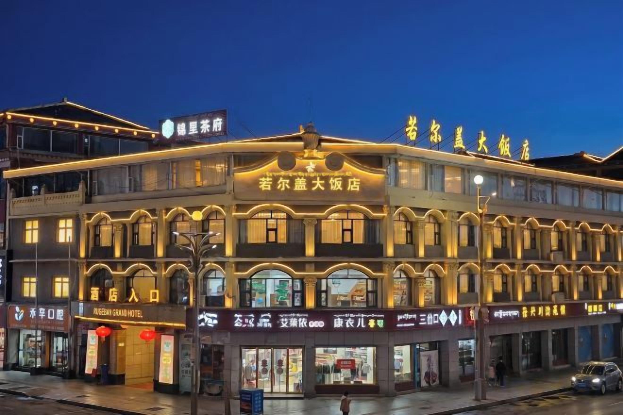 Un hôtel à plusieurs étages, de style architectural traditionnel, avec de nombreuses boutiques en rez-de-chaussée.