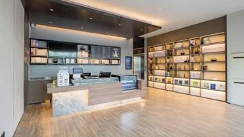 A reception area with a counter, digital check-in system, and a wall of informational displays.