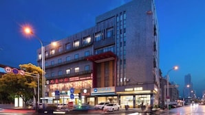 Un bâtiment moderne à plusieurs étages, doté de grandes fenêtres et d’une enseigne lumineuse.