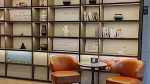 Une bibliothèque avec des étagères, une table et deux chaises.