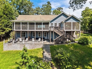 A two-story house with a covered patio, outdoor seating, and a staircase leading to a second level. - Lakefront Lake Anna, Dock, Views, Deck, Movies (Mineral)