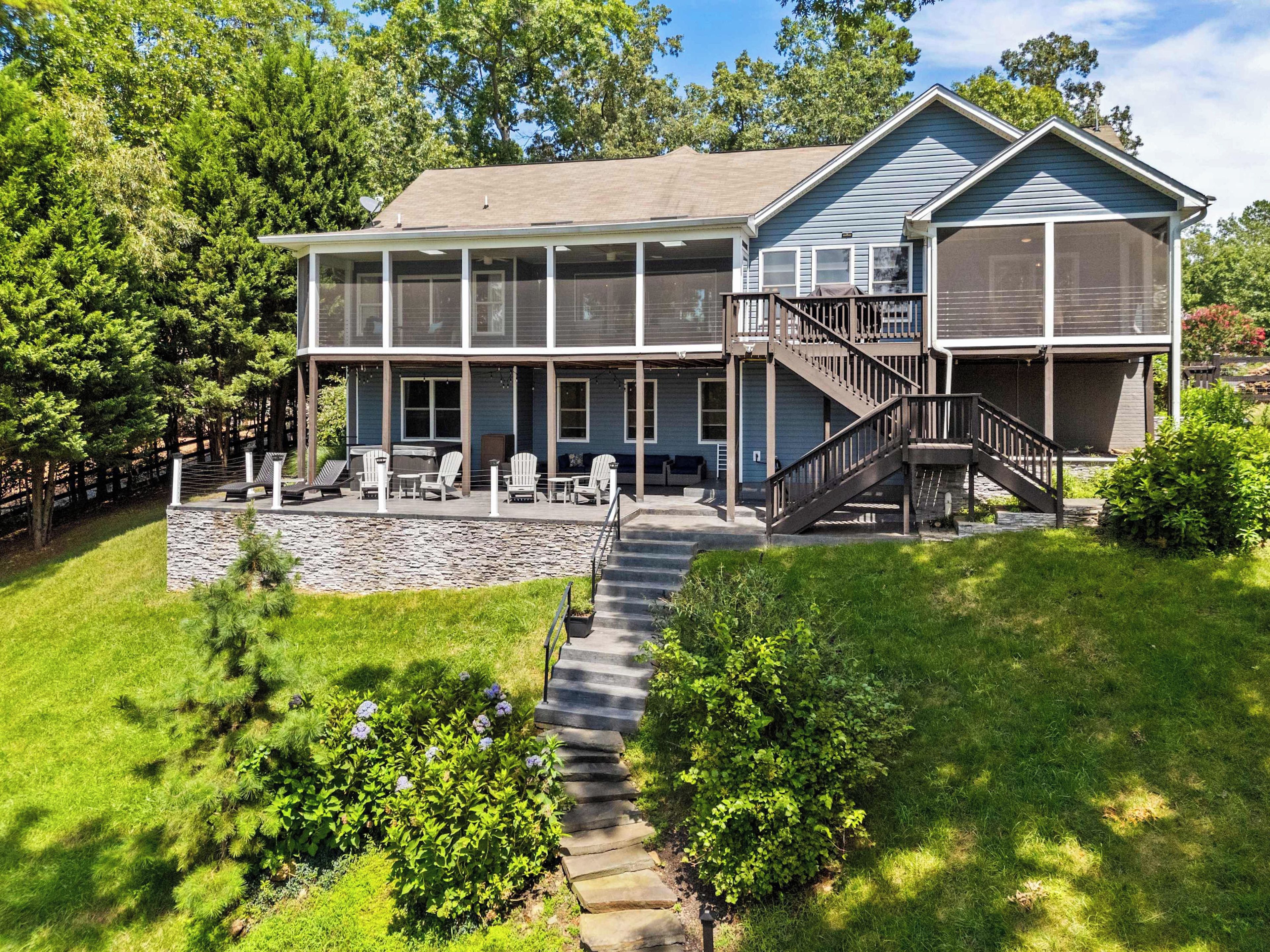 A two-story house with a covered patio, outdoor seating, and a staircase leading to the upper level.